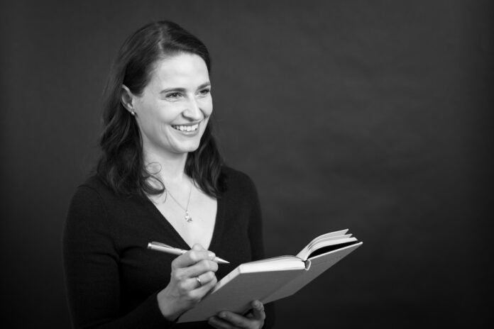 wiedereinstieg eltern autorin lena georgi buch und stift in der hand schwarz weiss