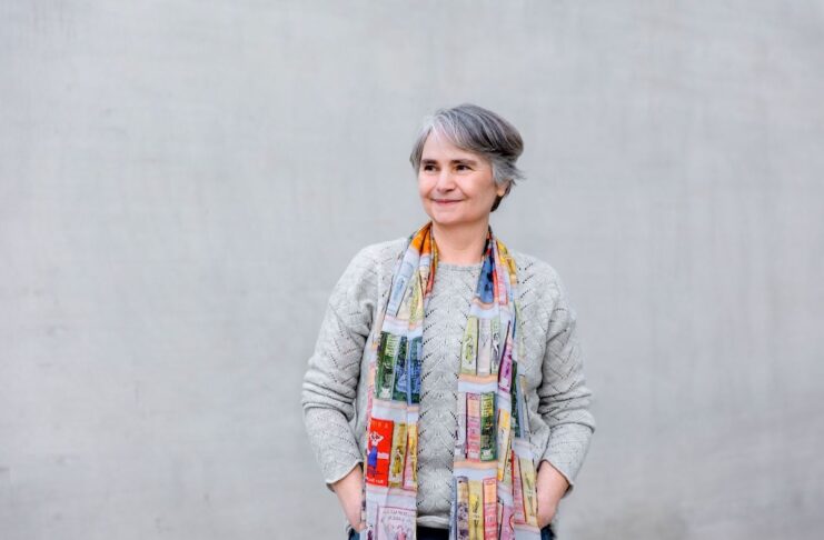Schreiben für Klarheit und Kreativität im Alltag und Beruf autorin beate fischer stehend grauer pulli vor grauem hintergrund mit buntem schal