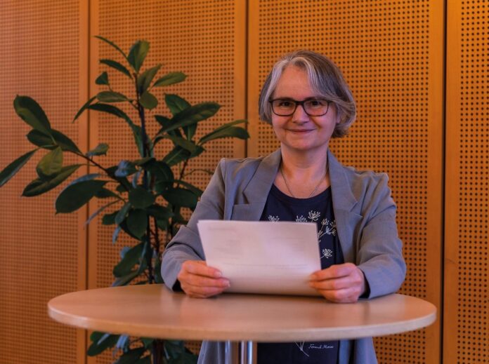 Führungsstil entwickeln: Mitarbeitende und Unternehmen stärken Beate Fischer Autorin stehend am Tisch mit Blatt in der Hand