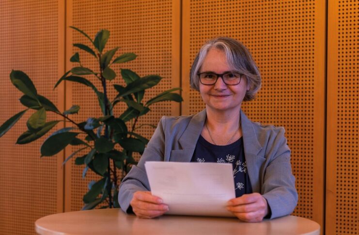 Führungsstil entwickeln: Mitarbeitende und Unternehmen stärken Beate Fischer Autorin stehend am Tisch mit Blatt in der Hand